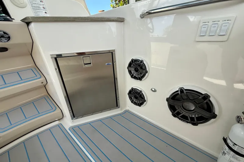 Slide: The Image of Boston Whaler 350 Realm 2025 interior with speakers, stainless steel compartment, and control switches. - 31