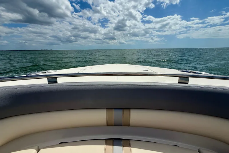 Slide: The Image of Boston Whaler 350 Realm 2025 cruising on open sea under a partly cloudy sky. - 46
