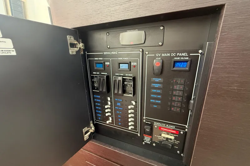 Slide: The Image of Electrical panel inside 2025 Boston Whaler 350 Realm boat, showcasing power controls and switches. - 54