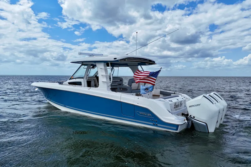Slide: The Image of 2025 Boston Whaler 350 Realm boat on open water, featuring American flag. - 7