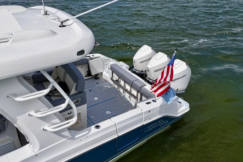 Slide: The Image of 2025 Boston Whaler 350 Realm boat with triple Mercury engines and American flag on water. - 8