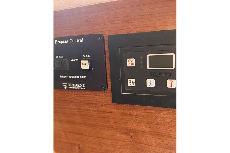 Slide: The Image of Control panels on a 2014 Hunter e33 boat, featuring propane and system controls. - 18