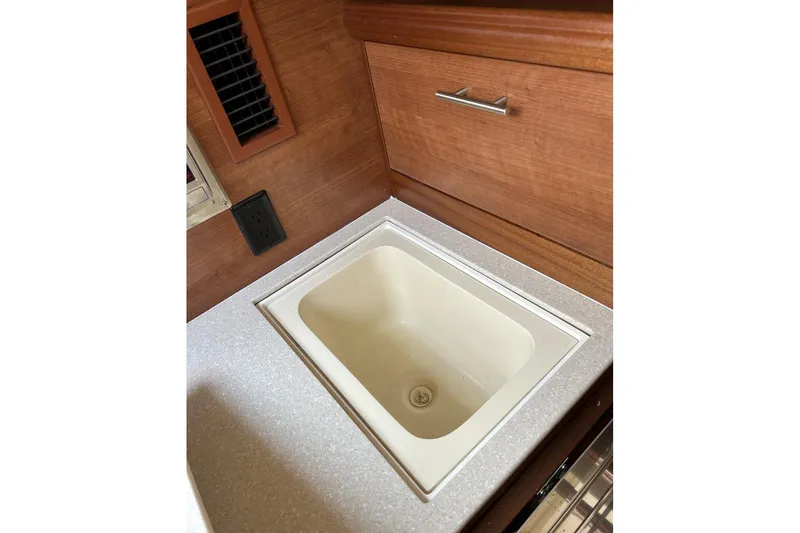 Slide: The Image of 2014 Hunter e33 yacht interior sink with wooden cabinetry and countertop. - 24