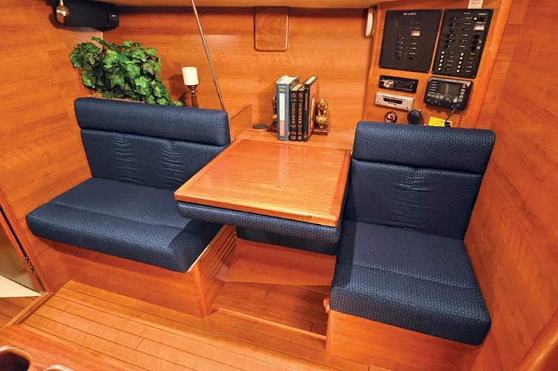 Slide: The Image of Interior of 2014 Marlow-Hunter 33 sailboat with blue seating and wooden table. - 29