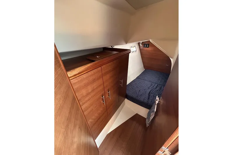 Slide: The Image of Cozy cabin interior of 2014 Hunter e33 sailboat with wooden cabinetry and bed. - 33