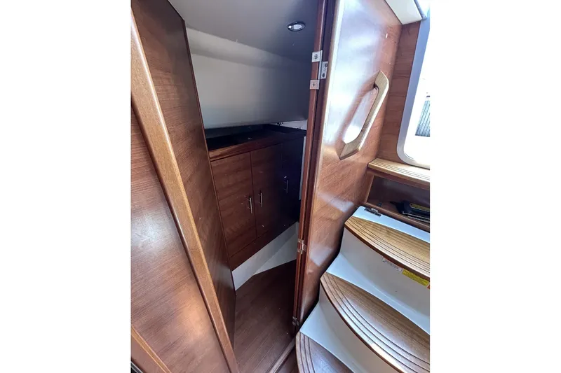 Slide: The Image of Interior view of 2014 Hunter e33 sailboat, featuring wooden cabinetry and steps. - 34