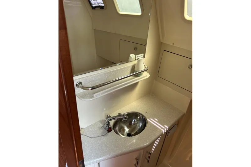 Slide: The Image of 2014 Hunter e33 yacht bathroom with sink, mirror, and storage cabinets. - 35