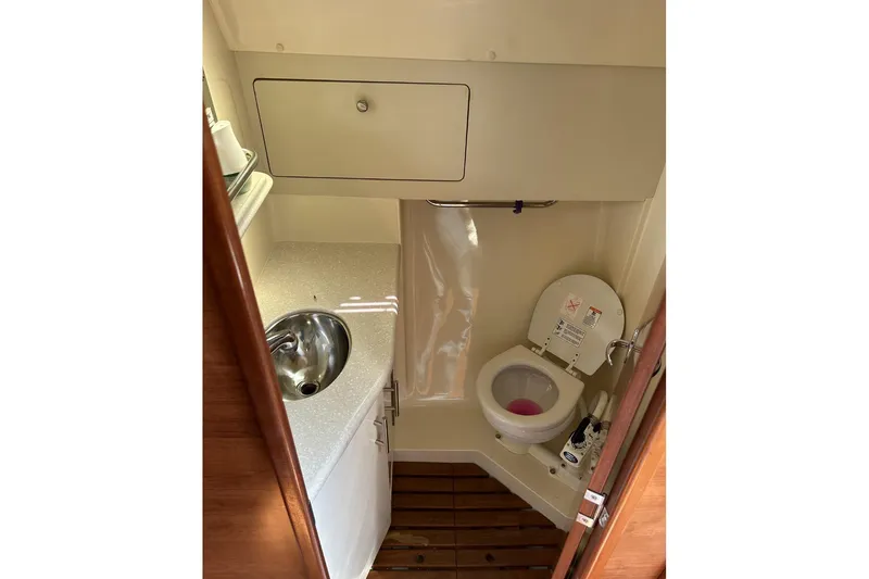 Slide: The Image of 2014 Hunter e33 yacht bathroom with sink, toilet, and wooden flooring. - 36