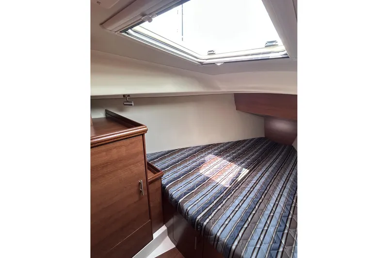 Slide: The Image of Cozy cabin interior of 2014 Hunter e33 sailboat with striped bedding and wooden cabinetry. - 37