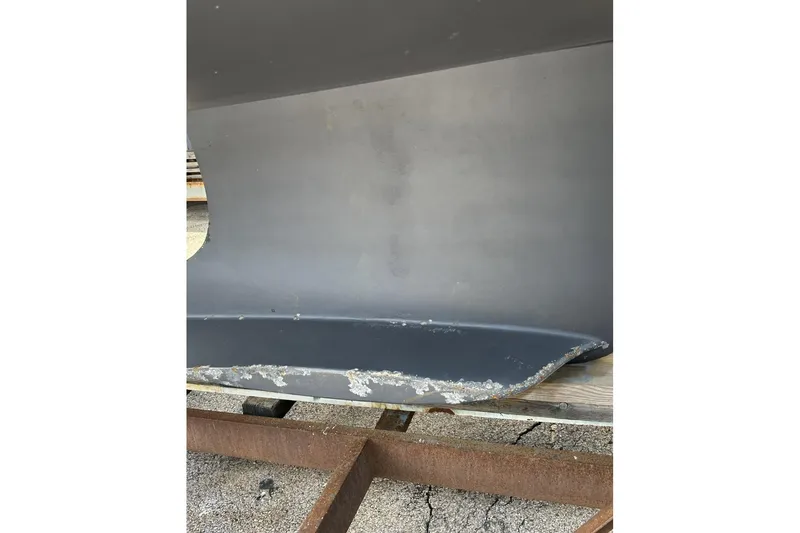 Slide: The Image of 2014 Hunter e33 sailboat keel with visible wear and damage. - 6