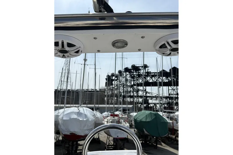Slide: The Image of 2014 Hunter e33 sailboat helm with marina and covered boats in background. - 9