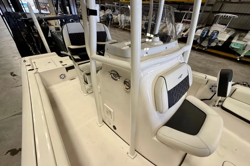 Slide: The Image of 2022 Tidewater 2300 Carolina Bay boat interior with seating and console in a showroom. - 21