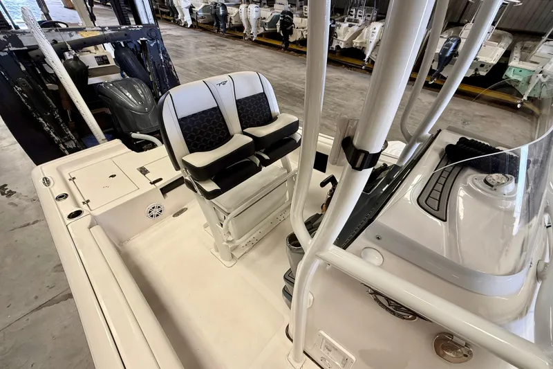 Slide: The Image of 2022 Tidewater 2300 Carolina Bay boat interior with dual seating and console in a showroom. - 23