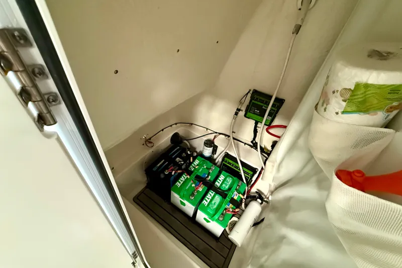 Slide: The Image of Battery compartment of 2022 Tidewater 2300 Carolina Bay boat, showing wiring and storage. - 29