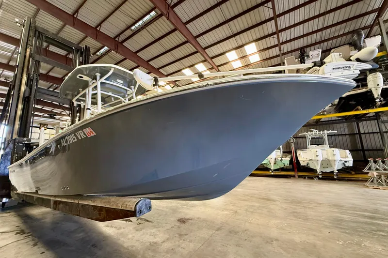 Slide: The Image of 2022 Tidewater 2300 Carolina Bay boat in storage facility, elevated on forklift. - 6