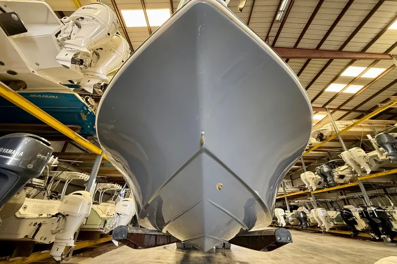 Slide: The Image of 2022 Tidewater 2300 Carolina Bay boat in storage, showcasing sleek hull design. - 7