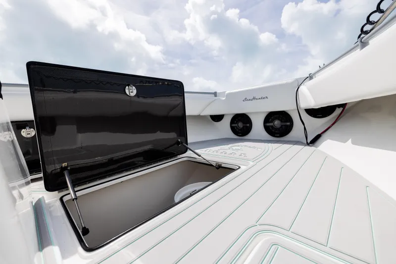 Slide: The Image of Open storage compartment on 2025 SeaHunter 30 Floridian boat deck under cloudy sky. - 13