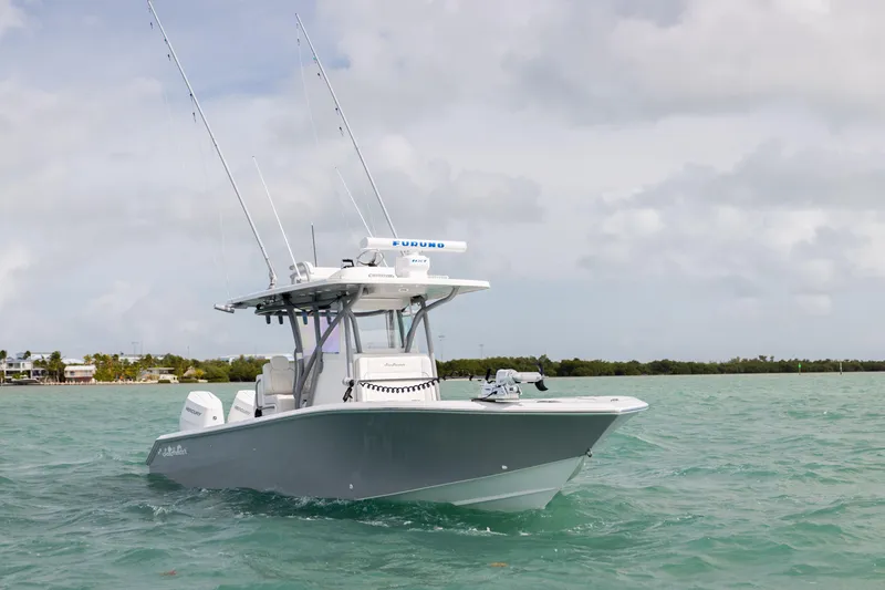 Slide: The Image of 2025 SeaHunter 30 Floridian boat cruising on turquoise waters under cloudy skies. - 4