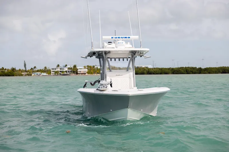 Slide: The Image of 2025 SeaHunter 30 Floridian boat cruising on turquoise water near a coastal area. - 6