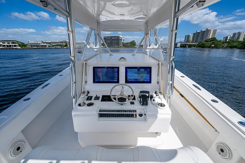 Slide: The Image of 2015 Invincible 42 Open Fisherman boat cockpit with dual navigation screens on a sunny day. - 12