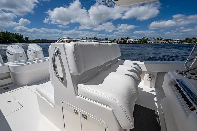 Slide: The Image of 2015 Invincible 42 Open Fisherman boat with white seating, on a sunny day by the water. - 13