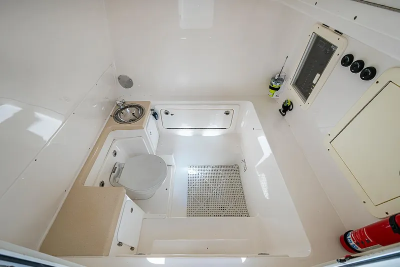 Slide: The Image of 2015 Invincible 42 Open Fisherman boat bathroom with toilet, sink, and fire extinguisher. - 14