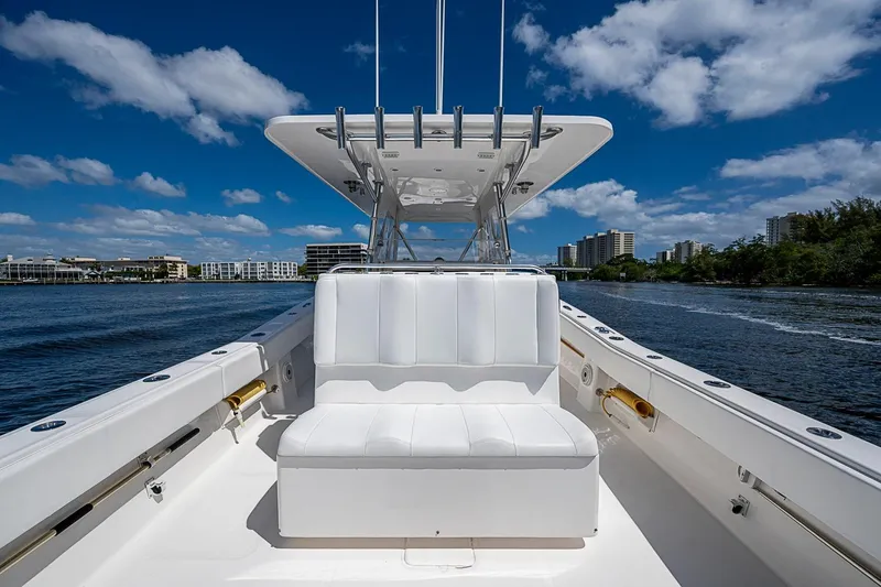 Slide: The Image of 2015 Invincible 42 Open Fisherman boat on water, clear sky, urban skyline background. - 15
