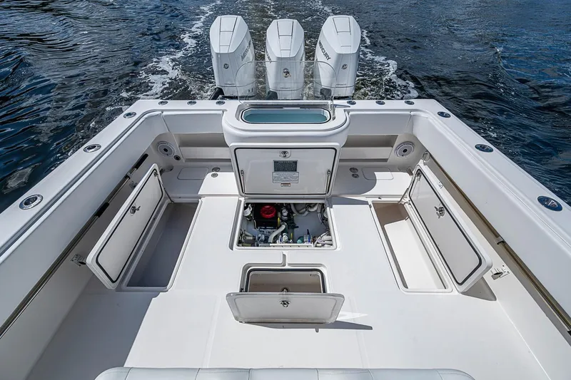 Slide: The Image of 2015 Invincible 42 Open Fisherman boat deck with storage compartments and triple engines. - 19