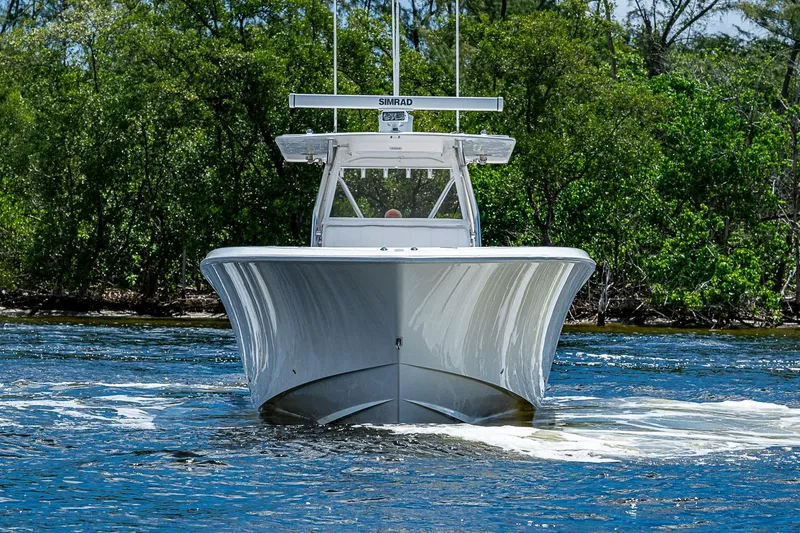 Slide: The Image of 2015 Invincible 42 Open Fisherman boat cruising on a scenic waterway. - 2