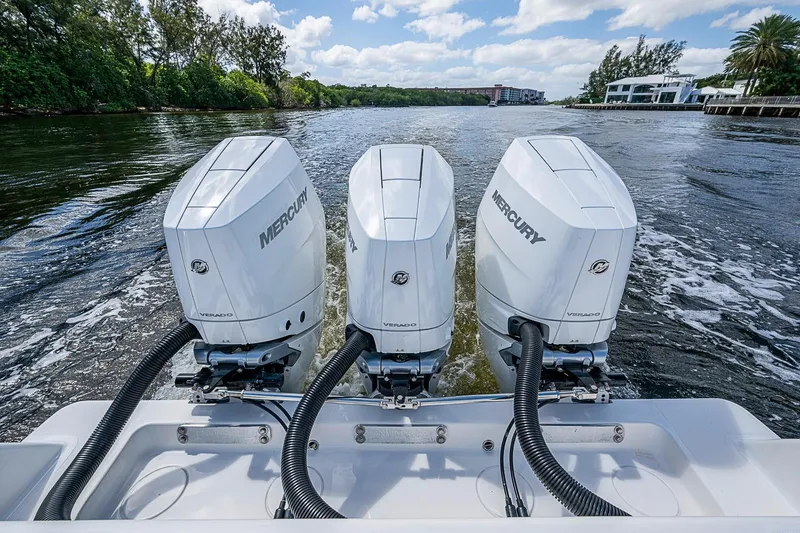 Slide: The Image of Triple Mercury Verado engines on a 2015 Invincible 42 Open Fisherman boat cruising on a scenic waterway. - 20