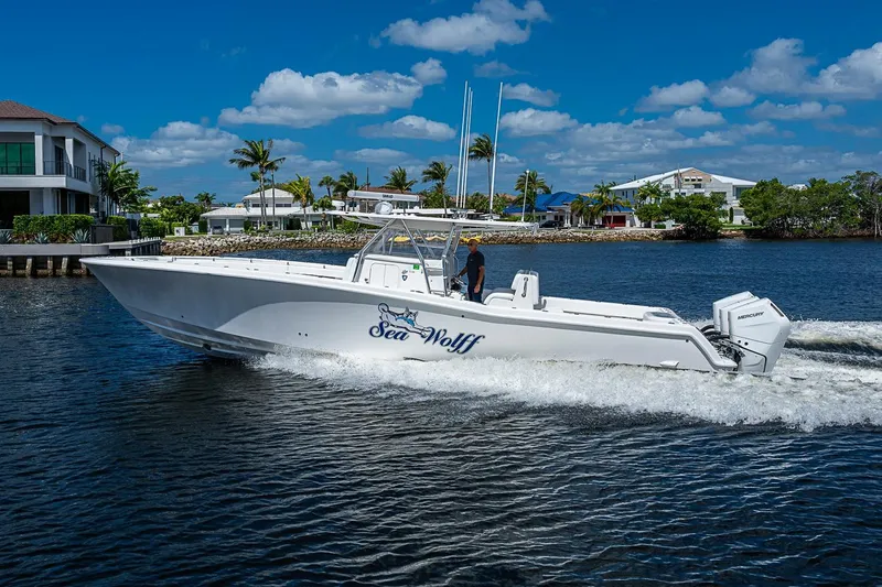 Slide: The Image of 2015 Invincible 42 Open Fisherman boat cruising on a sunny day near waterfront homes. - 26