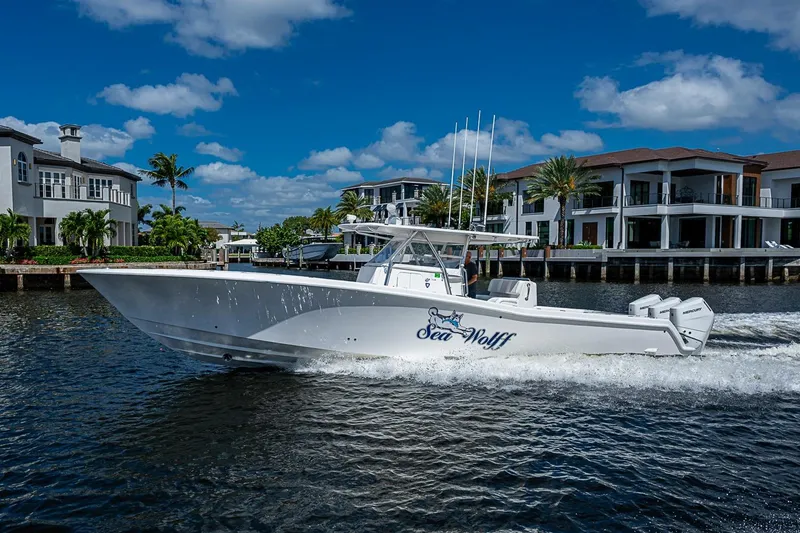 Slide: The Image of 2015 Invincible 42 Open Fisherman boat cruising near waterfront homes. - 27