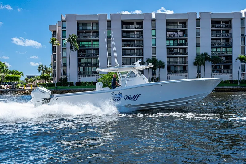 Slide: The Image of 2015 Invincible 42 Open Fisherman boat cruising near waterfront buildings. - 28