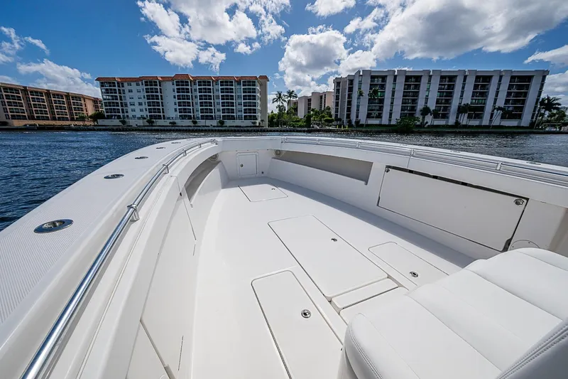 Slide: The Image of 2015 Invincible 42 Open Fisherman boat on water, with modern buildings in background. - 4