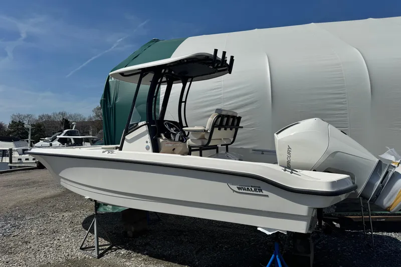 Slide: The Image of 2026 Boston Whaler 220 Dauntless boat with Mercury engine, displayed outdoors. - 1