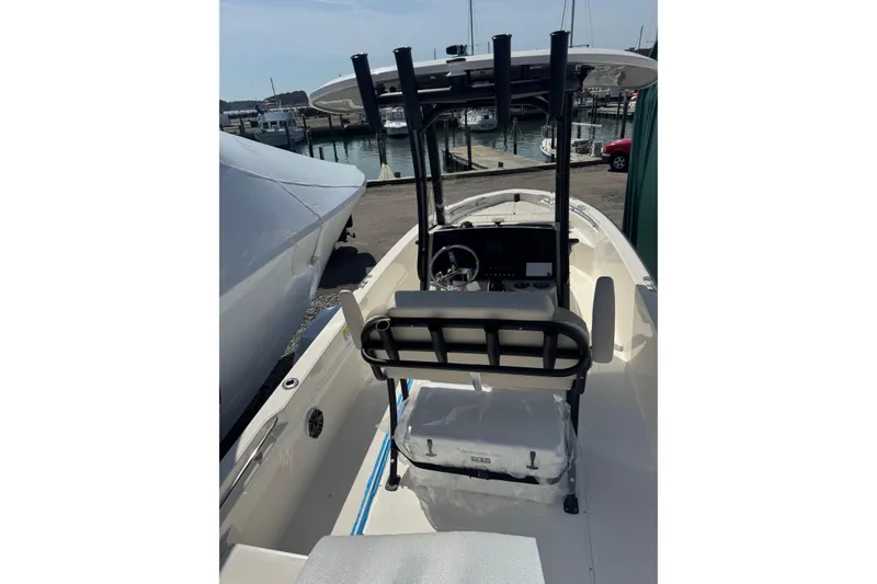 Slide: The Image of 2026 Boston Whaler 220 Dauntless boat interior with helm and seating, docked at marina. - 13