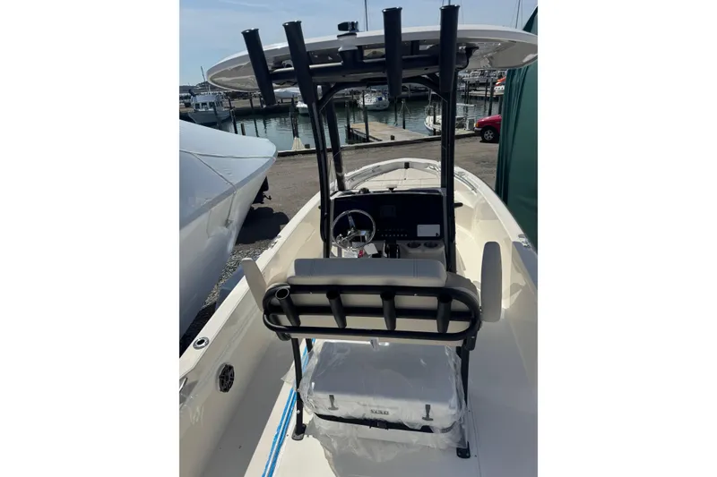 Slide: The Image of 2026 Boston Whaler 220 Dauntless boat interior with helm and seating, dockside view. - 14