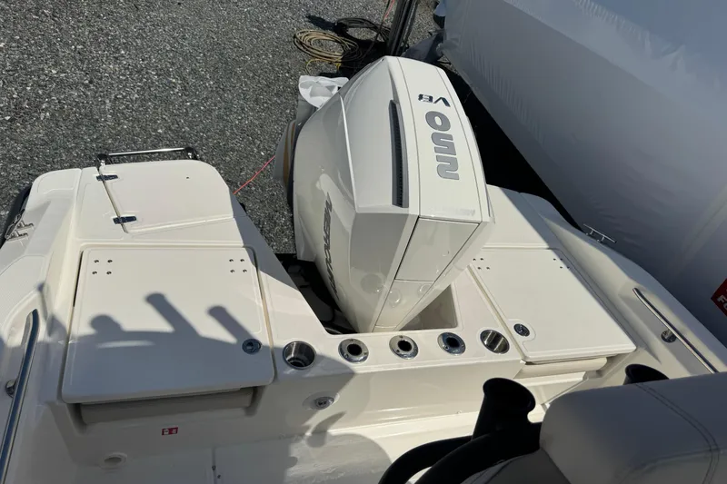 Slide: The Image of 2026 Boston Whaler 220 Dauntless boat with powerful outboard engine, docked on gravel surface. - 6