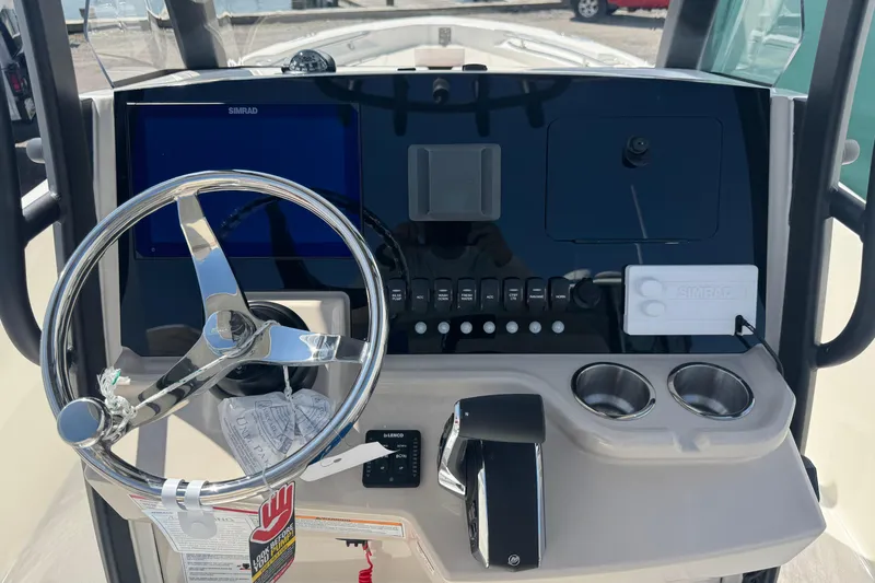 Slide: The Image of 2026 Boston Whaler 220 Dauntless helm with steering wheel and control panel. - 9