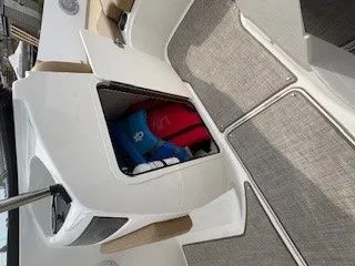 Slide: The Image of 2023 Bayliner VR5 Bowrider I/O with storage compartment and carpeted flooring. - 4