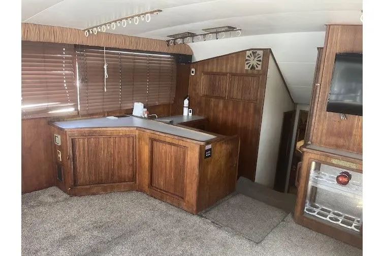 Slide: The Image of Interior of a 1989 Topaz 44 Sportfisherman yacht with wood paneling and carpeted flooring. - 17