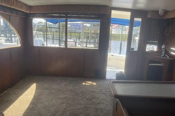 Slide: The Image of Interior of 1989 Topaz 44 Sportfisherman yacht with carpeted floor and marina view. - 19