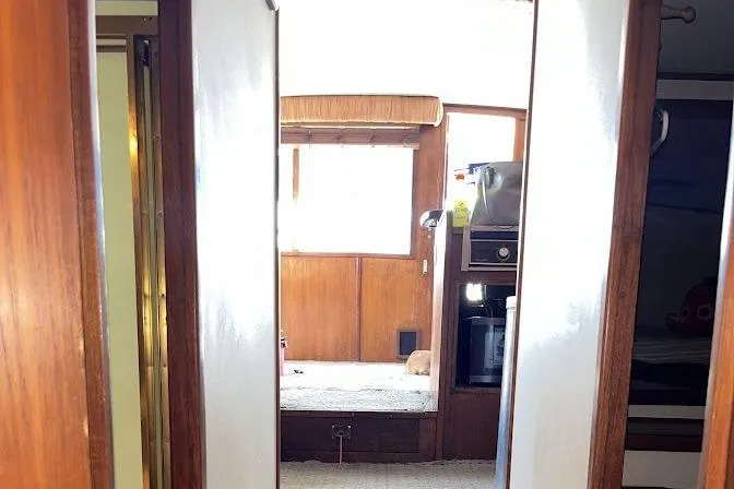 Slide: The Image of Interior view of 1989 Topaz 44 Sportfisherman boat, featuring wood paneling and cozy cabin space. - 23