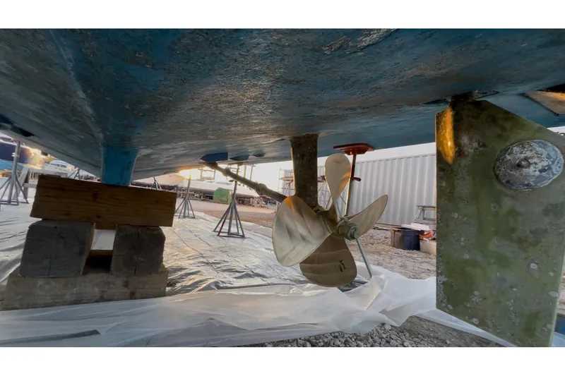 Slide: The Image of Underneath view of a 1989 Topaz 44 Sportfisherman boat, showing propeller and hull. - 33