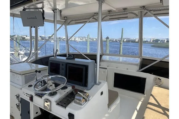 Slide: The Image of 1989 Topaz 44 Sportfisherman helm with Garmin navigation, overlooking marina. - 8