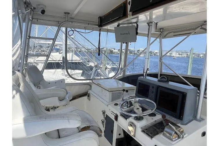 Slide: The Image of 1989 Topaz 44 Sportfisherman cockpit with navigation equipment and white seating. - 9
