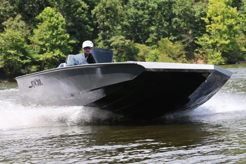 Slide: The Image of Manufacturer Provided Image: 2026 Excel EX 183 boat speeding on a lake with lush green trees in the background. - 3