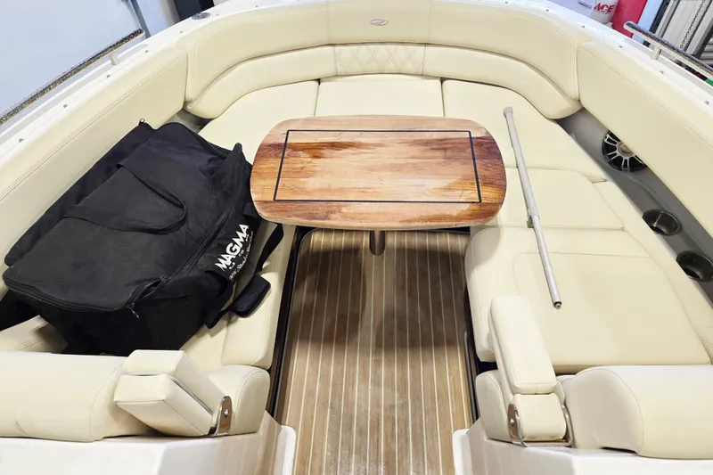 Slide: The Image of 2020 Regal 2800 Bowrider interior with wooden table and seating, featuring a Magma bag. - 12
