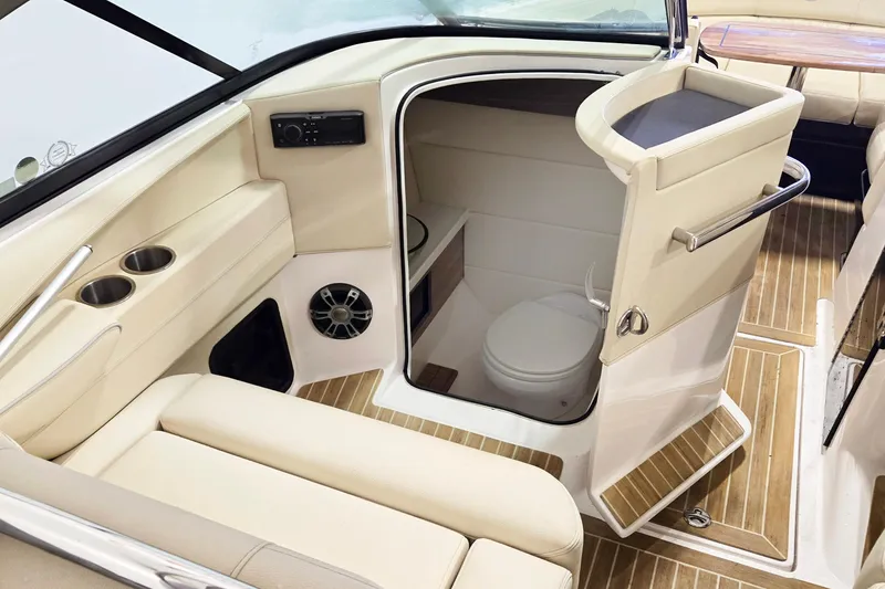 Slide: The Image of 2020 Regal 2800 Bowrider interior with a compact marine toilet and seating area. - 5