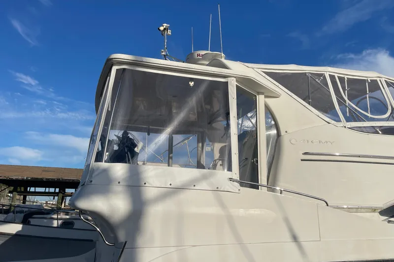 Slide: The Image of 2008 Carver 41 Cockpit Motor Yacht with clear enclosure, docked under blue sky. - 10